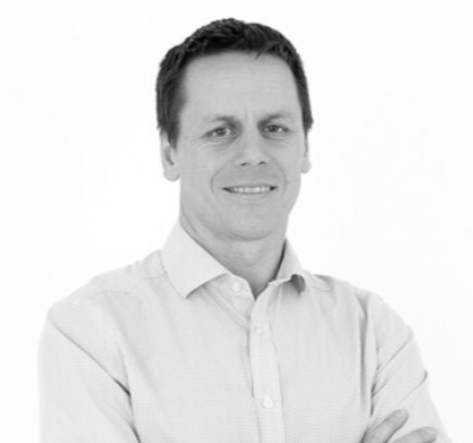 Angus Robinson profile picture - man with short dark hair wearing a light-coloured button-up shirt, smiling slightly with arms crossed, posing against a white background.